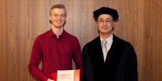 Nimo Beeren and George Fletcher posing at Nimo's graduation ceremony. Nimo is holding his degree.