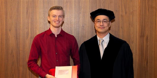 Nimo Beeren and George Fletcher posing at Nimo's graduation ceremony. Nimo is holding his degree.